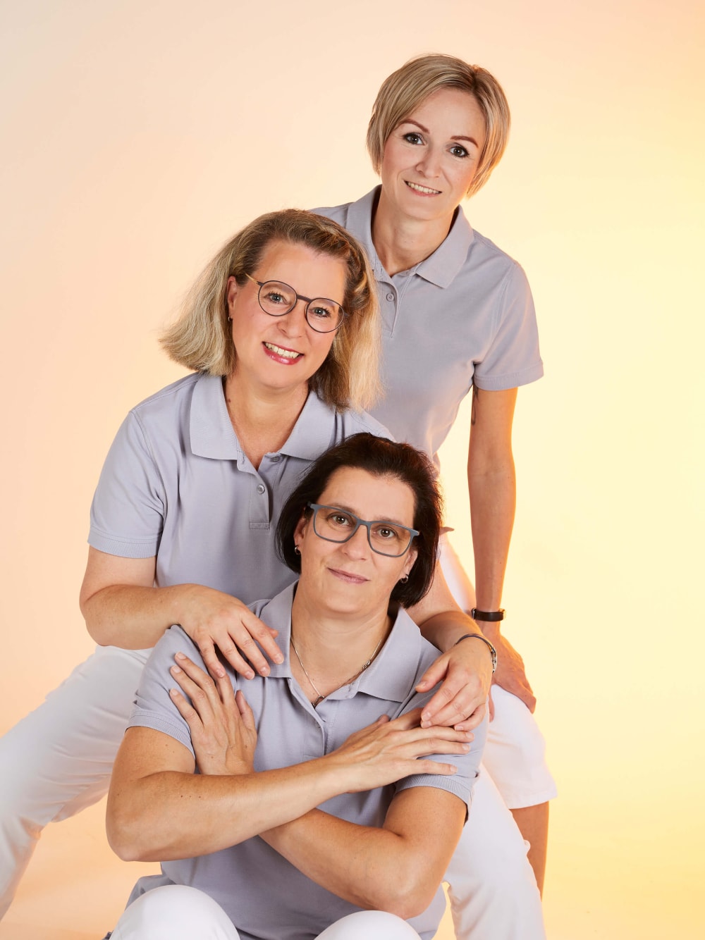Drei Frauen mit farbigem T-Shirt und weißer Hose